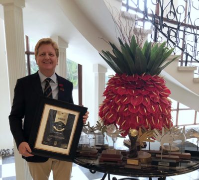 The Oyster Box' general manager holding the Lilizela Award for Best 5-star Hotel in SA. 